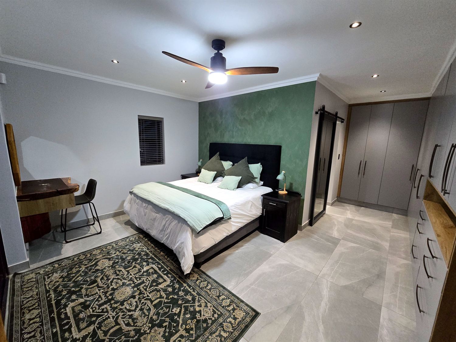 Bedroom with a deep green feature wall
